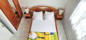 una piccola camera da letto con un letto con cuscini bianchi di Bungalow charmant à Capesterre 67 m² avec piscine partagee a Capesterre-Belle-Eau Altre 6 foto