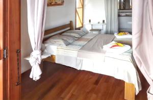 a bedroom with two beds with curtains and a wooden floor at Bungalow charmant à Saint-François avec jardinB in Saint-François