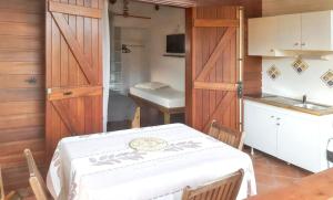 a room with a table and a kitchen with a table and chairs at Bungalow charmant à Saint-François avec jardinB in Saint-François