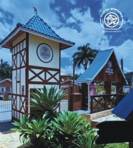 un pequeño edificio con un cartel en un parque en Pousada Villa Da Montanha, en São Bento do Sapucaí
