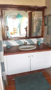a bathroom with a sink and a mirror at Bungalow charmant à Saint-François avec jardinB in Saint-François +4 photos