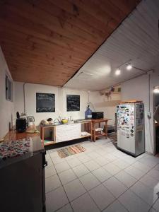 a kitchen with a refrigerator and a table in it at SURFHOUSE Pichilemu in Pichilemu