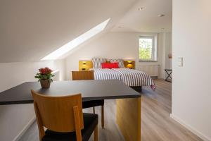 a bedroom with a bed and a table and chairs at Sieben Zimmer & Ein Tisch in Bobingen