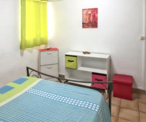 a bedroom with a bed and a dresser and a table at Appartement charmeur à Sainte-Anne, 40 m², jardin in Sainte-Anne