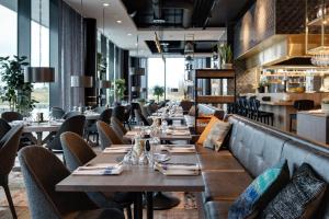 a restaurant with wooden tables and chairs and a bar at Clarion Hotel Air in Sola