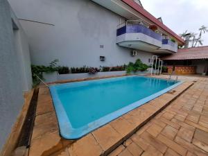 a large blue swimming pool in front of a building at Pousada dos Girassóis in Palmas