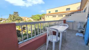 a balcony with a white table and chairs on it at Studio charmant avec balcon à Hyères - 20 m² - Vue sur jardin in Hyères +3 photos