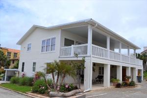 a white house with a balcony on a street at Cottage One Gorgeous Ocean View From 60 foot Deck in Saint Augustine Beach
