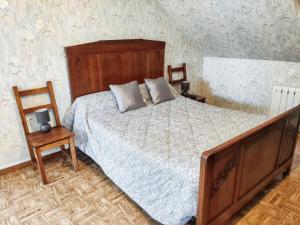 a bedroom with a large bed and a chair at Chaleureuse Maison de Campagne avec Terrasse et Cheminée in Lignières-de-Touraine