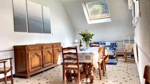 Un comedor con una mesa y algunas sillas. en Maison moderne à Saint-Pol-de-Léon avec jardin privé, en Saint-Pol-de-Léon 15 fotos más