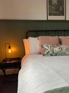 a bed with a green headboard and a side table at City Cottage in Lincoln