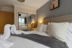 a bedroom with a bed with a towel animal on it at Quay Escape - Short Stays UK Ltd in Exeter