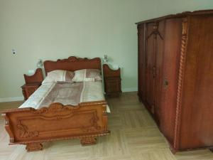 a bedroom with a wooden bed and a wooden dresser at Villa Padiego in Alojzów
