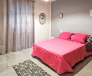 a bedroom with a large pink bed with pink pillows at Appartement spacieux à Bastia avec vue mer et montagne. in Bastia