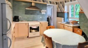 kuchnia z kuchenką, zlewem i lodówką w obiekcie Maison de charme à Wuenheim avec jardin et terrasse w mieście Wuenheim