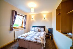
a bedroom with a bed and a desk at Kilcumin Guest House in Inverness
