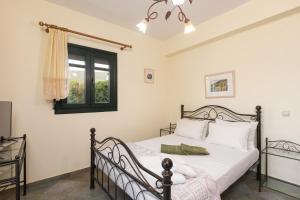 a bedroom with a bed and a window at Villa Platanaki in Kerveli