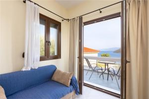 a living room with a couch and a balcony at Villa Platanaki in Kerveli