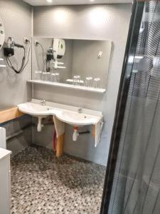 a bathroom with two sinks and a mirror at Maison accueillante avec jardin proche d'Échenans. in Échenans