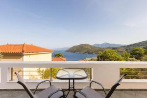 a balcony with chairs and a view of the water at Villa Platanaki in Kerveli