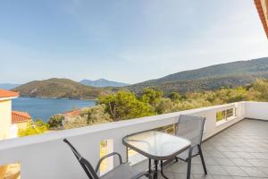 a balcony with chairs and a view of the water at Villa Platanaki in Kerveli