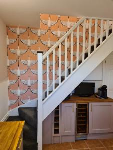 a staircase in a house with an orange wall at City Cottage in Lincoln +4 photos