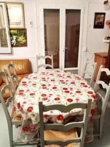 a dining room table with a floral tablecloth on it at Maison accueillante à Montluçon avec jardin privatif in Montluçon +14 photos