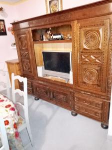 a wooden entertainment center with a television in it at Maison accueillante à Montluçon avec jardin privatif in Montluçon