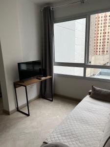 a bedroom with a bed and a desk and a window at LK Centro 3 in Belo Horizonte +43 photos