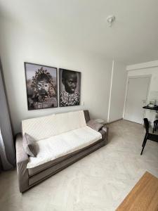 a living room with a couch and three pictures on the wall at LK Centro 3 in Belo Horizonte