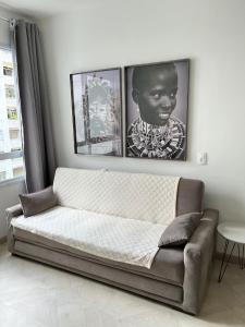 a couch in a living room with pictures on the wall at LK Centro 3 in Belo Horizonte