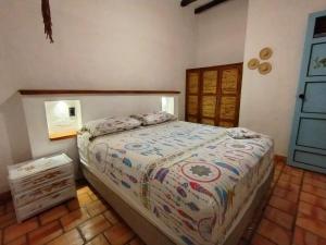 a bedroom with a bed and a wooden floor at Apartamento Colonial VaraEchada in Barichara