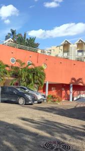 zwei Autos vor einem Gebäude geparkt in der Unterkunft Charmant appartement à La Trinité avec piscine partagée - 40 m² in La Trinité