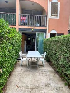 a table and chairs sitting on a sidewalk in front of a house at Appartement charmant à Canet-en-Roussillon / 35 m² / Piscine. in Canet-en-Roussillon +4 photos
