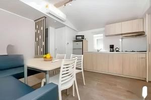 a kitchen and dining room with a table and chairs at Bungalow confortable à Nans-les-Pins avec piscine partagée in Nans-les-Pins