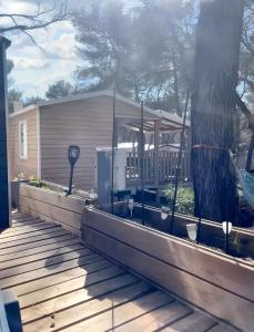 a deck with a house in the background at Bungalow confortable à Nans-les-Pins avec piscine partagée in Nans-les-Pins