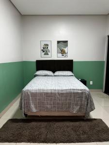 a bedroom with a bed with green and white walls at Casa 05 próximo ao centro Delior 2 in Palmas
