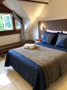 a bedroom with a large bed with a blue comforter at Casa Figueira na Pedra - SPA Suites in Florianópolis +70 photos