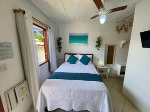 a bedroom with a bed and a ceiling fan at Suites Casa Azul-Vila do Abraão- conforto, limpeza, ótima localização in Abraão