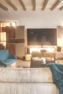 a living room with a couch and a large screen tv at Villa élégante à Beauchêne avec piscine privée in Beauchêne