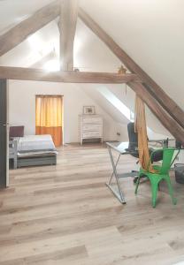 a attic bedroom with a bed and a green chair at Villa élégante à Beauchêne avec piscine privée in Beauchêne +57 photos