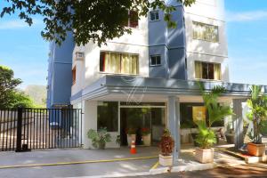 Un edificio azul y blanco con plantas delante. en Di Roma Rio Quente TURISMO, en Rio Quente
