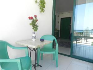 een tafel met stoelen en een vaas met bloemen erop bij Il Gabbiano casa al mare in Bisceglie