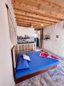 a bedroom with a blue bed in a room at Mashrum House in Dahab
