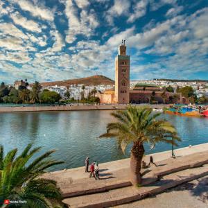 a building with a clock tower next to a body of water at Marokkoreizen in Fès