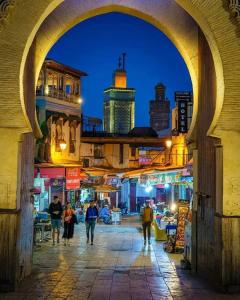 a group of people walking down a street at night at Marokkoreizen in Fès