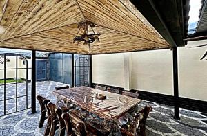a dining room with a large wooden table and chairs at Gabala Double Villas in Gabala