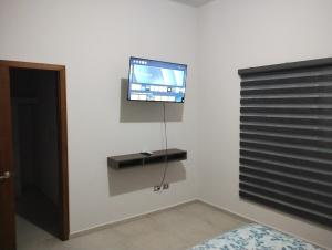 a room with a tv on a wall with a window at executive home, vacation work in Ramos Arizpe