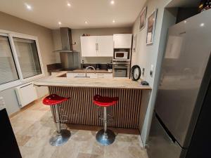 cocina con encimera y 2 taburetes rojos en Romance à l' affiche, en Valence-dʼAgen