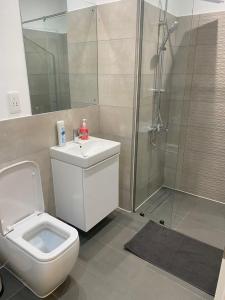 Un baño con ducha, inodoro y lavabo. en Tripview Apartments at Loxwood House, en Accra